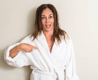 Güzel orta yaş kadın, ıslak saç sürpriz bir havluyla giyen yüz kendine işaret parmağı