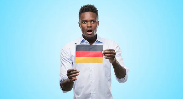 Joven Hombre Afroamericano Sosteniendo Bandera Alemana Asustado Shock Con Una —  Fotos de Stock