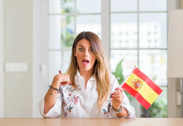 Mujer Joven Casa Sosteniendo Bandera España Con Cara Sorpresa Señalándose —  Fotos de Stock