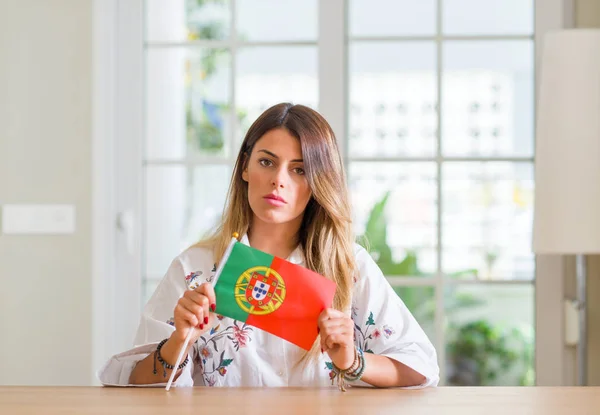 Mujer Joven Casa Sosteniendo Bandera Portugal Con Una Expresión Confianza —  Fotos de Stock