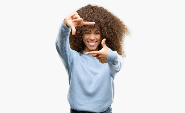 アフリカ系アメリカ人の女性の手で作るフレームと幸せそうな顔で指を笑顔のセーターを着てします 創造性と写真のコンセプト — ストック写真