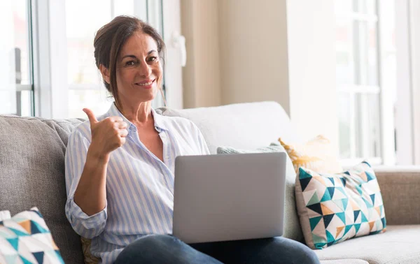 Middle Aged Woman Using Laptop Sofa Pointing Hand Finger Happy — Stock Photo, Image