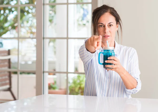 Μέσης Ηλικίας Γυναίκα Πίνοντας Κούνημα Γάλακτος Ένα Ποτήρι Δείχνοντας Δάχτυλο — Φωτογραφία Αρχείου