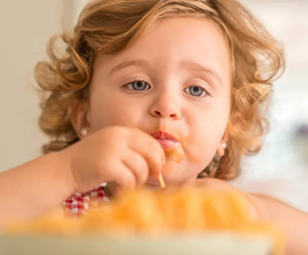 自宅手でスパゲッ ティーを食べて美しい金髪の子供のクローズ アップ — ストック写真