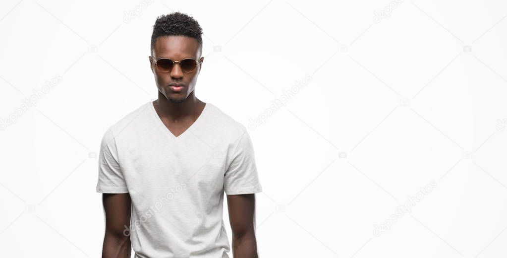 Young african american man wearing sunglasses with a confident expression on smart face thinking serious