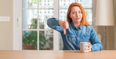 Bir fincan kahve kızgın yüzü, eksi işareti aşağı antipati başparmak ile gösterilen, ret kavramı ile tutan Kızıl saçlı kadın