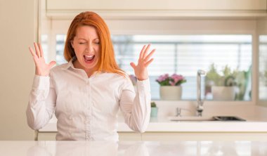 Kızıl saçlı kadın deli ve silah ile başarı için çılgın kutlama mutfak at kaldırdı ve heyecanlı çığlık gözler kapalı. Kazanan kavramı