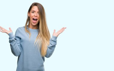 Kazak ve kot çok mutlu ve heyecanlı, kazanan ifade büyük gülümseme ile çığlık ve ellerini kaldırdı zaferini kutluyor giyen güzel genç kadın