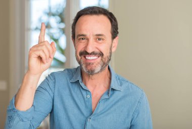 Yakışıklı ortadaki adam bir fikirle sürpriz yaş ya da gülen yüz, bir numara ile işaret parmağı soru