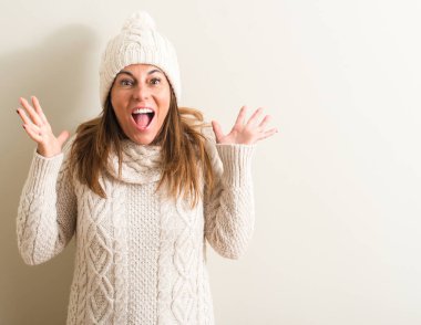 Kocaman bir gülümseme ile çığlık zaferini kutluyor ve ellerini kaldırdı yün kış cap çok mutlu ve heyecanlı, kazanan ifade giyen orta yaş kadın