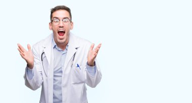 Yakışıklı genç adam kutluyor deli doktor ve çığlık kaldırdı ve açık gözleri hayret silah ile başarı için heyecanlı. Kazanan kavramı
