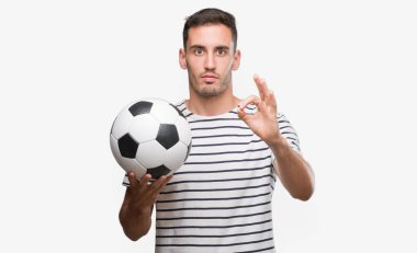 Parmak, mükemmel sembolü ile ok işareti yapıyor futbol futbol tutan yakışıklı genç