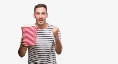 Gurur çığlık ve zafer ve başarı çok heyecanlı, duygu tezahürat kutluyor yakışıklı genç adam yeme patlamış mısır