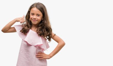 Pembe elbise esmer Latin kız gülümseyerek el ve parmak telefonda konuşmak ile telefon jest yapıyor. Kavramları iletişim.