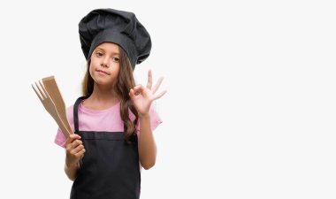 Esmer Latin kız aşçı üniforması parmak, mükemmel sembolü ile ok işareti yapıyor