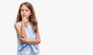 Esmer İspanyol kız emin çapraz kollar ve çeneme kaldırdı el ile gülümseme ile kameraya bakıyor. Pozitif düşünce.