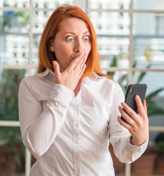 Roodharige Vrouw Met Behulp Van Smartphone Thuis Cover Mond Met — Stockfoto