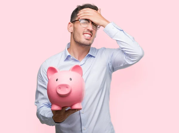 Handsome Young Man Holding Piggy Bank Stressed Hand Head Shocked — Stock Photo, Image