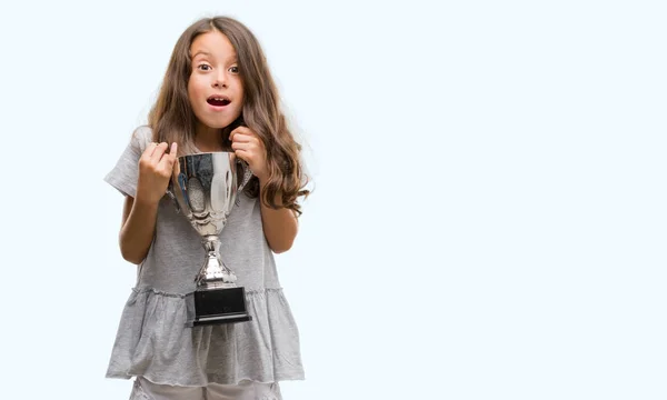 Brunette Hispanic Girl Holding Trophy Scared Shock Surprise Face Afraid — Stock Photo, Image