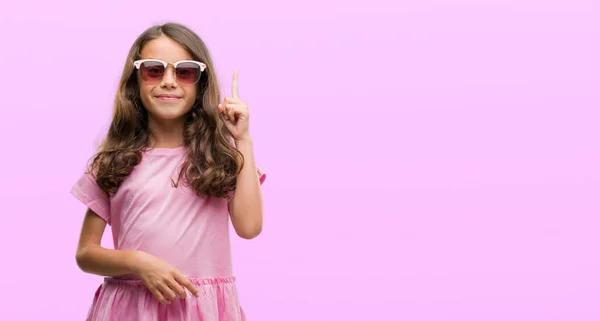 Menina Hispânica Morena Usando Óculos Sol Surpreso Com Uma Ideia — Fotografia de Stock