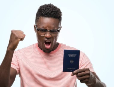 Genç Afrikalı Amerikalı adam Alman pasaportu rahatsız tutarak ve öfke, çılgın ve yükseltilmiş el, öfke kavramı ile diye bağıran ile sinirli bağırarak