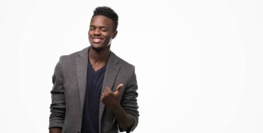 Ok işareti, başparmak ile parmak, mükemmel işareti yapıyor kocaman bir gülümseme ile mutlu bir ceket giyen genç Afro-Amerikan adam