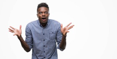 Çılgın ve silah ile başarı için hayran mavi gömlek kutluyor giyen genç Afro-Amerikan adam kaldırdı ve açık gözleri çığlık heyecanlı. Kazanan kavramı