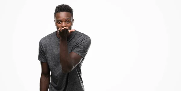 Joven Hombre Afroamericano Vistiendo Camiseta Gris Mirando Cámara Soplando Beso —  Fotos de Stock