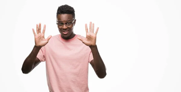 年轻的非洲裔美国人穿着粉红色 T恤显示和指向十的手指 而微笑着自信和快乐 — 图库照片