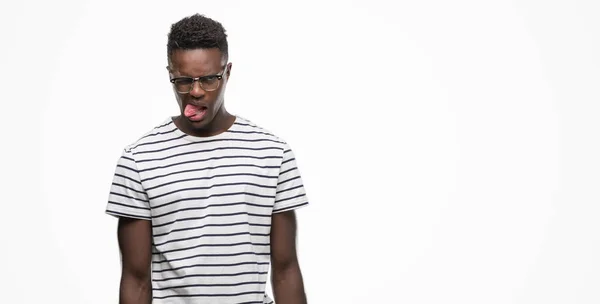 メガネと海軍 シャツ舌を身に着けている若いアフリカ系アメリカ人を面白い表現に満足 感情の概念 — ストック写真