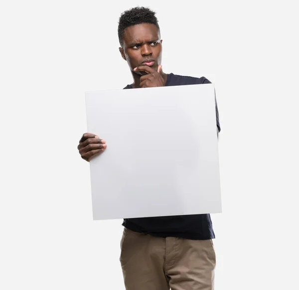 Young African American Man Holding Banner Serious Face Thinking Question — Stock Photo, Image