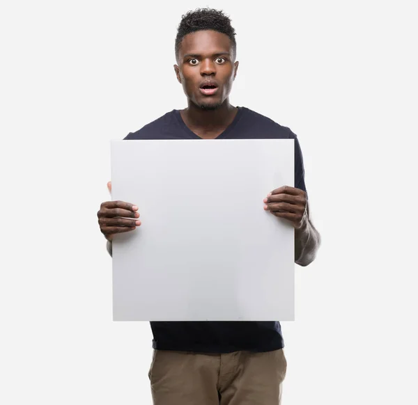 Jovem Afro Americano Segurando Uma Bandeira Assustada Choque Com Rosto — Fotografia de Stock