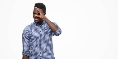 Afro-Amerikan delikanlı mavi gömlek gülümseyen, parmakları ile mutlu yüz üzerinden seyir göz el ile ok jest yapıyor.