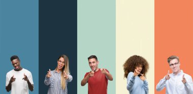 Group of people over vintage colors background pointing fingers to camera with happy and funny face. Good energy and vibes. clipart