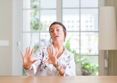 Genç kadın şok bağırarak evde korkuyor ve korku ifade dur hareketi el ile ile çok korkmuş. Panik kavramı.