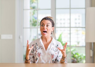 Genç kadın evde deli ve deli bağırarak ve agresif ifade ve silah kaldırdı bağırıyor. Hayal kırıklığı kavramı.