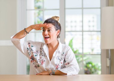 Genç kadın evde çok mutlu ve gülümseyen uzakta el ile üzerine kafa arıyorum. Arama kavramı.