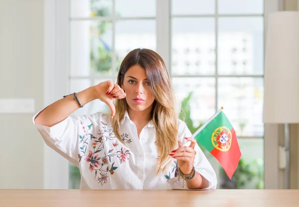 Mujer Joven Casa Sosteniendo Bandera Portugal Con Cara Enojada Signo —  Fotos de Stock