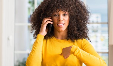 Afrikalı-Amerikalı kadın kendisine sürpriz yüz işaret parmağı ile Smartphone kullanarak