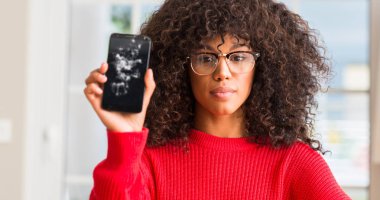 Kendinden emin bir ifade ile kırık smartphone ciddi düşünme acımak yüz tutan Afrikalı-Amerikalı kadın