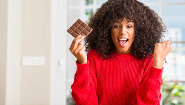 Afrikalı-Amerikalı kadın ev gurur çığlık ve kutluyor zafer ve başarı çok heyecanlı, çikolata barda yemek duygu tezahürat