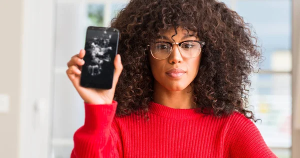 Kendinden emin bir ifade ile kırık smartphone ciddi düşünme acımak yüz tutan Afrikalı-Amerikalı kadın