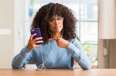 El ve parmak ile işaret çok mutlu Smartphone kullanarak güzel bir Afrikalı-Amerikalı kadın