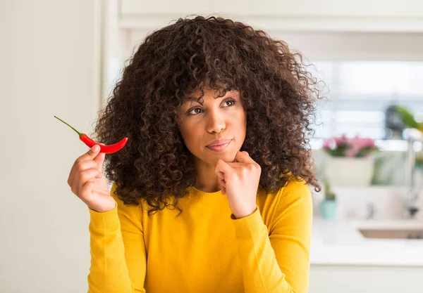 非洲裔美国人吃红辣椒的女人严肃的面孔思考问题 非常困惑的想法 — 图库照片