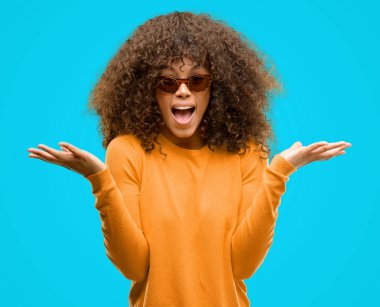 Kocaman bir gülümseme ile çığlık zaferini kutluyor ve ellerini kaldırdı orage kazak çok mutlu ve heyecanlı, kazanan ifade giyen Afrikalı-Amerikalı kadın