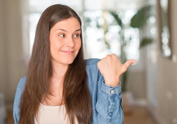 Genç güzel kadın evde el ve parmak ile mutlu yüz gülümseyen ile yukarı dönük