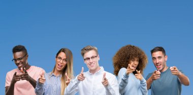 Grup mavi blackground fotoğraf makinesi ile mutlu ve komik yüz için parmakları işaret üzerine arkadaşıyla bileşimi. İyi enerji ve vibes.