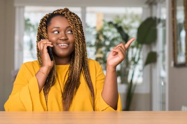 Afrikalı-Amerikalı kadın el ve parmak ile tarafına işaret çok mutlu Smartphone kullanarak