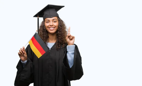 Jovem Hispânica Vestindo Uniforme Formatura Segurando Bandeira Alemanha Surpreso Com — Fotografia de Stock