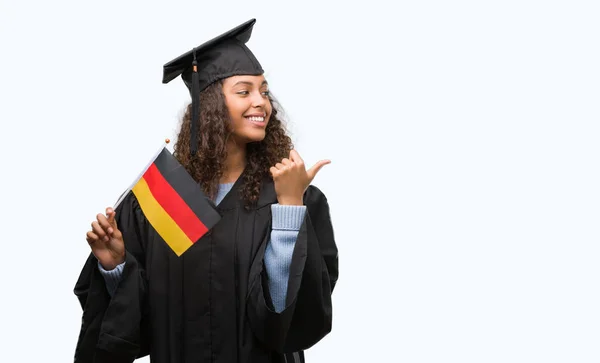 Молодий Латиноамериканського Жінка Носить Випускний Рівномірного Тримає Прапор Німеччини Вказуючи — стокове фото